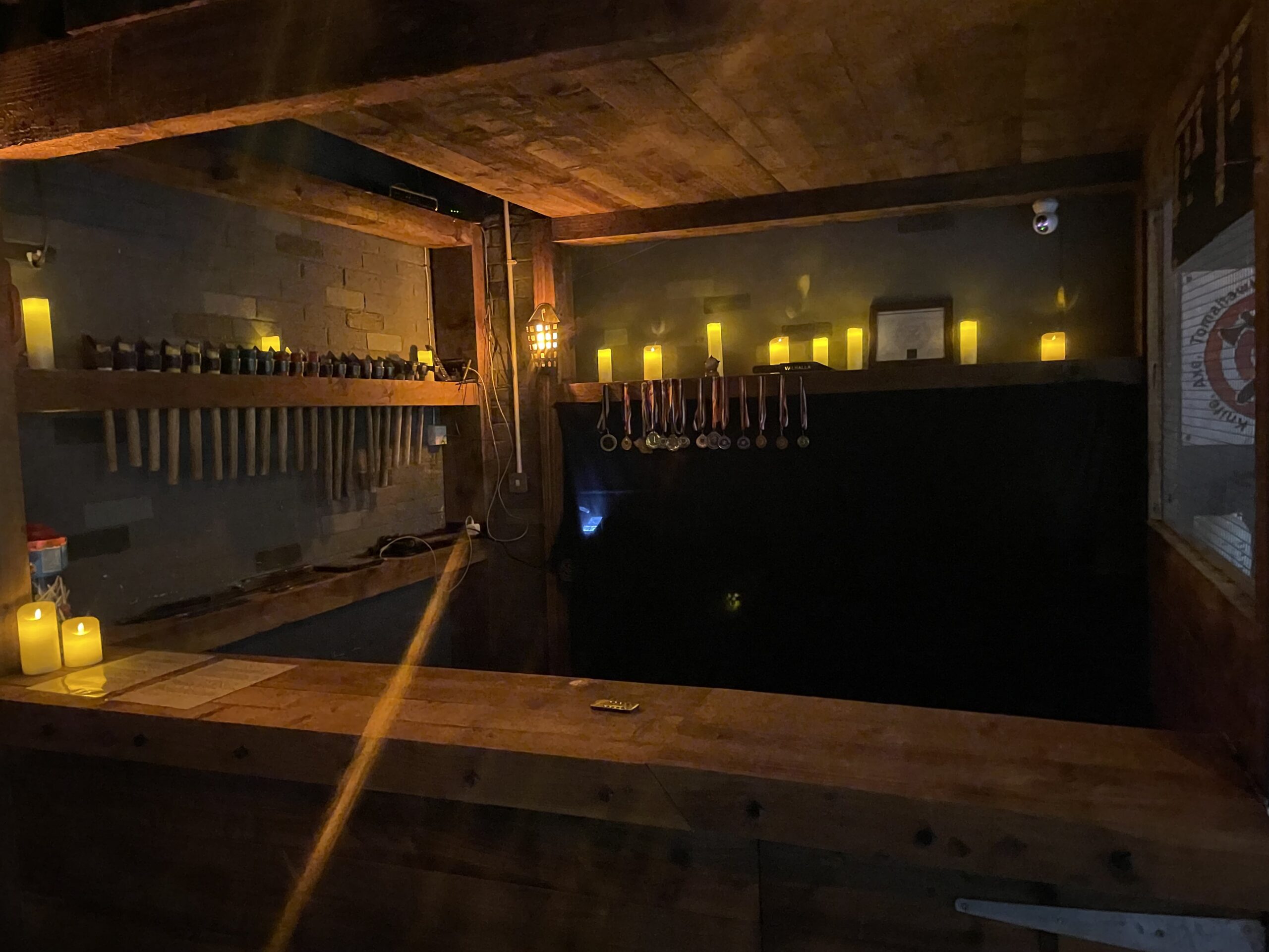 Group of friends enjoying axe throwing at Valhalla Lanes in Colchester – a Viking-themed venue led by UK axe-throwing champion Jace. Players smile and celebrate as axes hit wooden targets, highlighting one of the top Essex activities for group events.